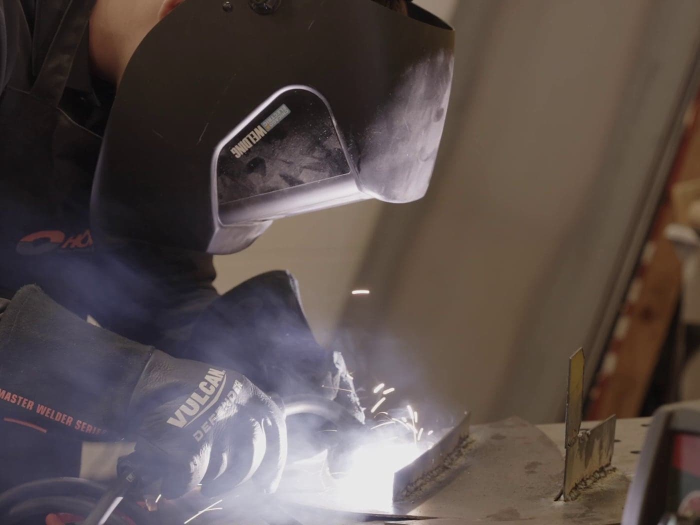 Highland Prep West student welding in protective gear in the fabrication shop